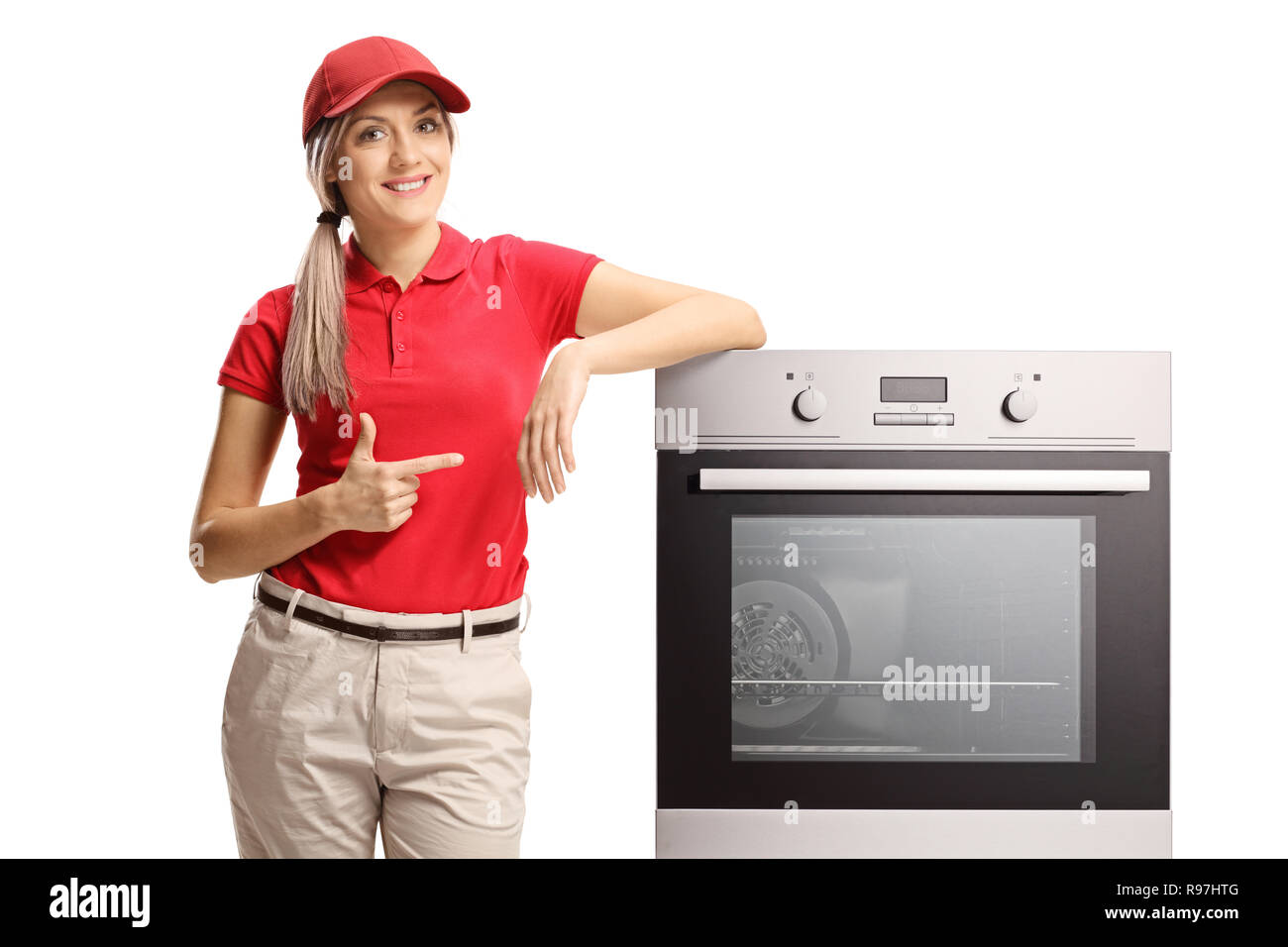 Saleswoman pointing to an electrcal oven isolated on white background Stock Photo