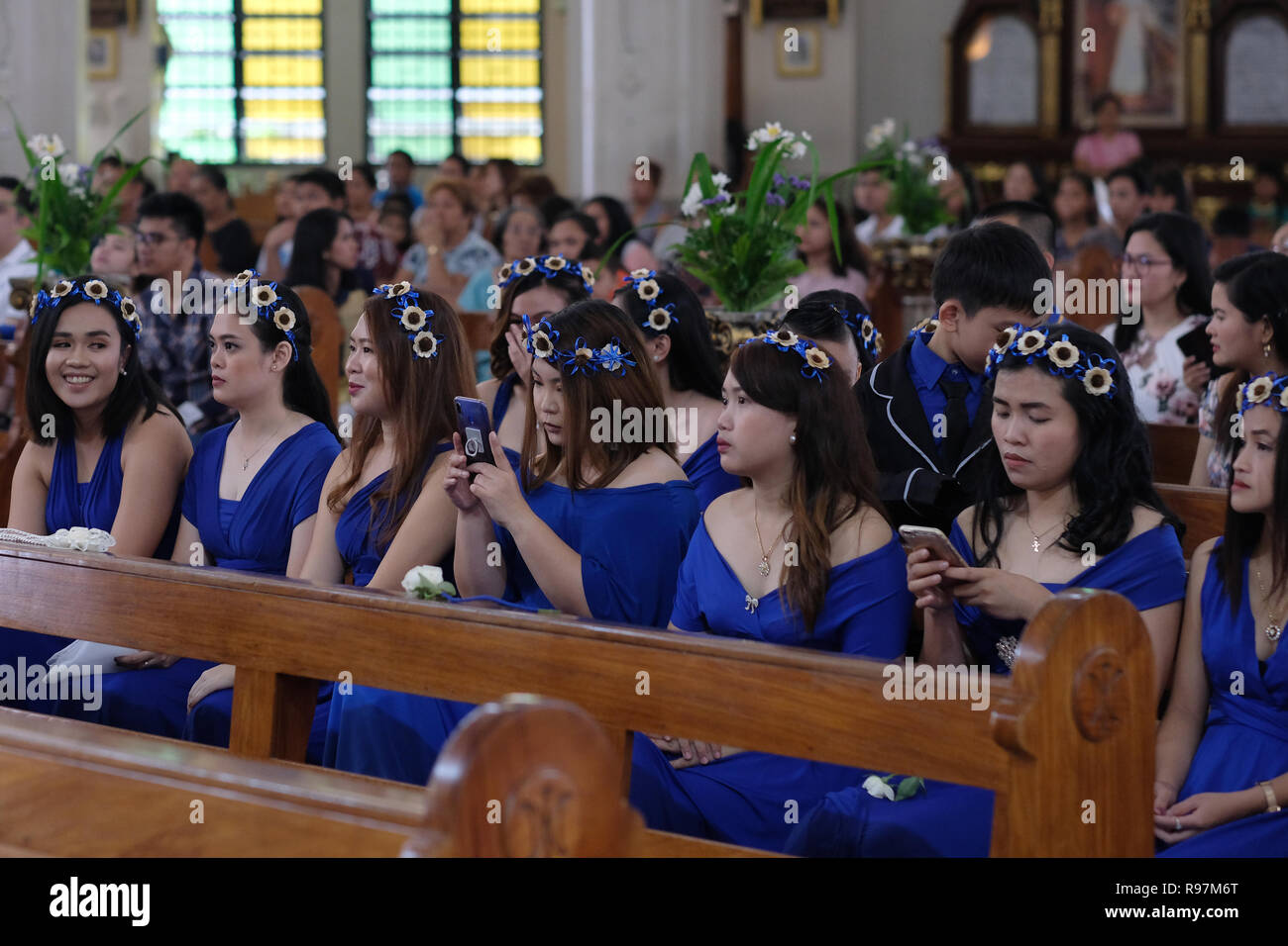 A group of young Filipino women inside the Roman Catholic Antipolo Cathedral or National Shrine of Our Lady of Peace and Good Voyage located in the city of Antipolo, in the province of Rizal in the Philippines. Stock Photo