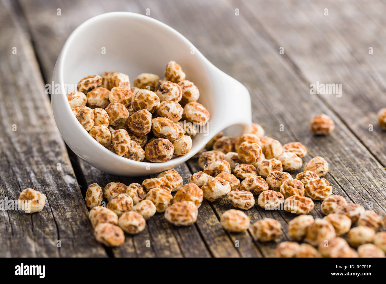Tiger nuts. Tasty chufa nuts. Healthy superfood on old wooden table. Stock Photo