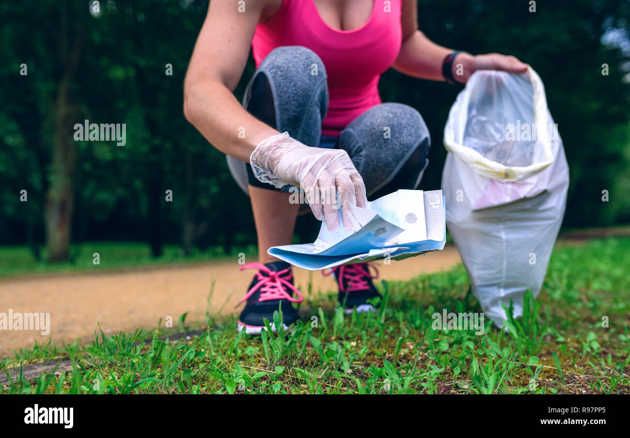 Girl picking up trash doing plogging Stock Photo
