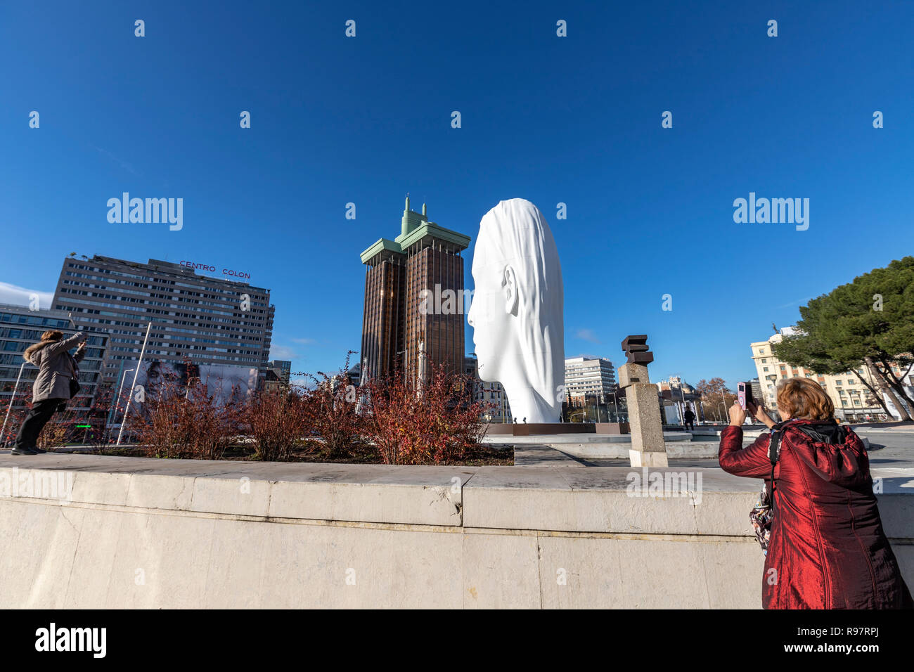 People taking pictures of Julia, white marble sculpture by Jaume Plensa in Plaza Colon, Madrid, Spain Stock Photo