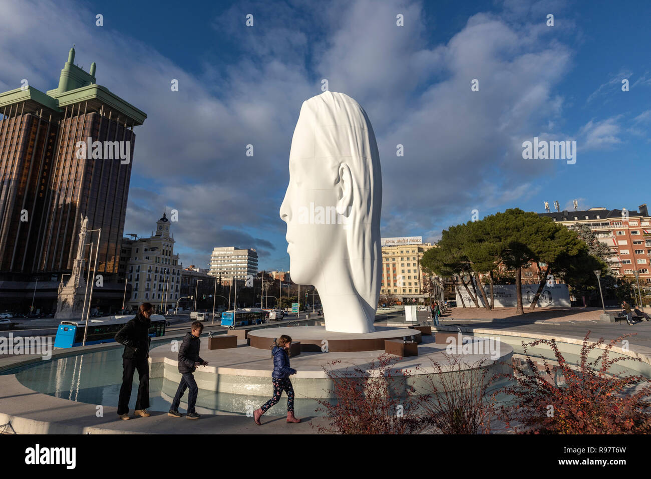 Family walking around the Julia, white marble sculpture by Jaume Plensa in Plaza Colon, Madrid, Spain Stock Photo