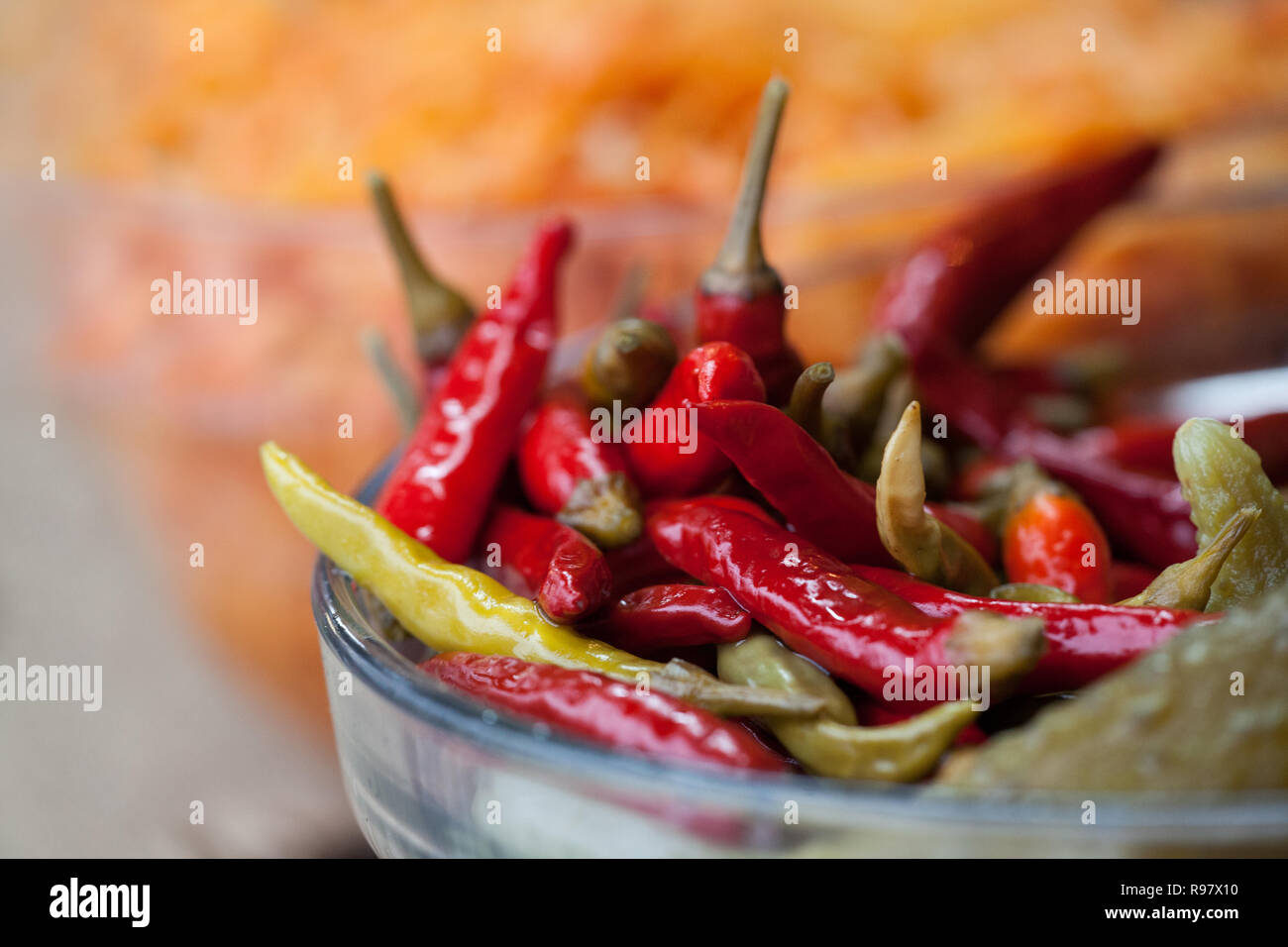 Marinated hot peppers in glassy bowl. Pickled chili peppers Stock Photo