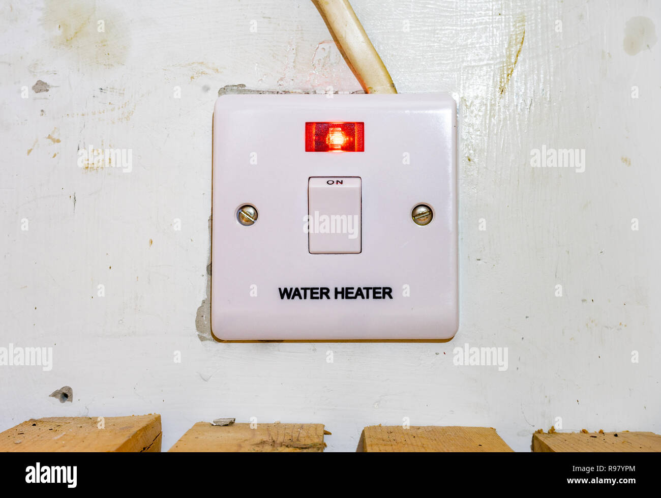 UK Water Heater switch with red light on indicating that it is in use Stock Photo