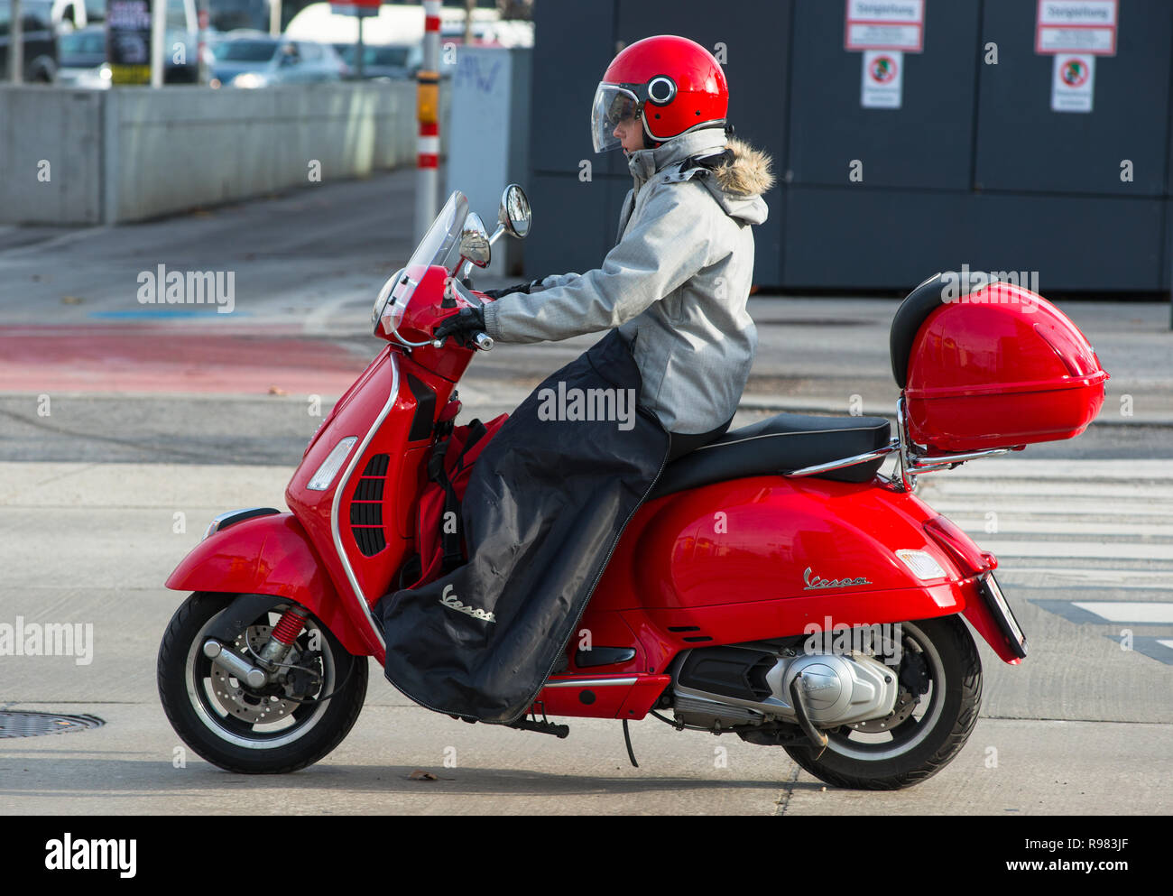 Girl on a red Vespa scooter with matching helmet on the streets of Vienna, Austria. Stock Photo