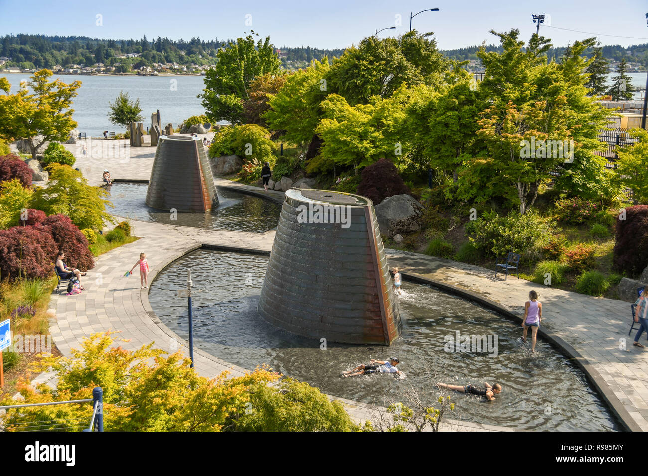BREMERTON, WASHINGTON STATE, USA - JUNE 2018: Young people playing in the water features of the Harborside Fountain park in Bremerton, WA. Stock Photo