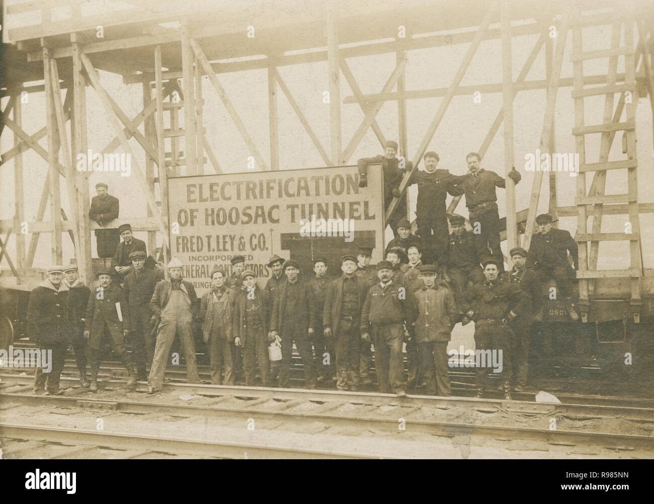 Antique c1911 photograph, work crew for the electrification of the Hoosac Tunnel. The Hoosac Tunnel is a 4.75-mile (7.64 km) active railroad tunnel in western Massachusetts that passes through the Hoosac Range, an extension of Vermont's Green Mountains. It runs in a straight line from its east portal, along the Deerfield River in the town of Florida, to its west portal in the city of North Adams. SOURCE: ORIGINAL PHOTOGRAPH. Stock Photo