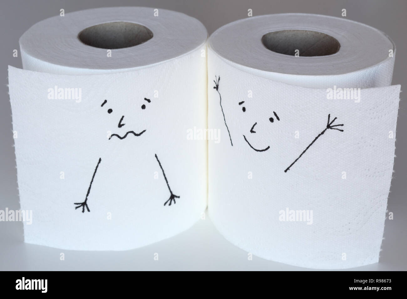 Two white toilet paper rolls sketched with a scared and a cheerful face