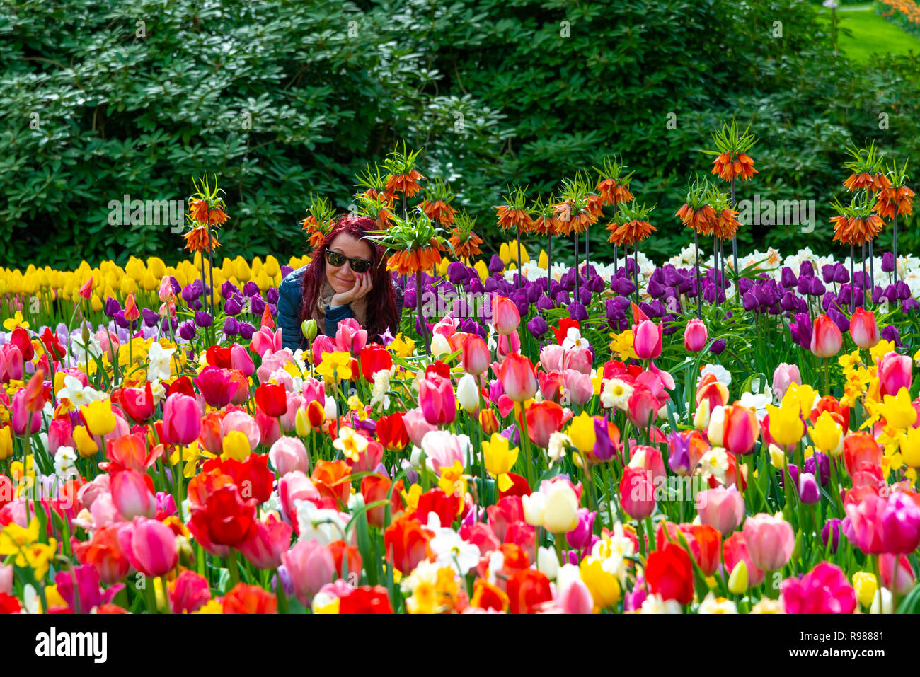 Pretty girl smiling amongst the beautiful spring flowers in the