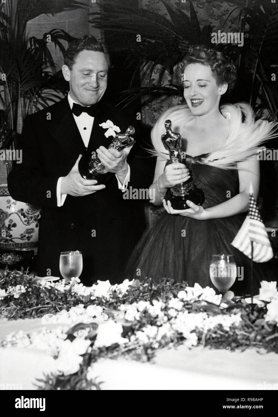11th Annual Academy Awards / 1939.   Cedric Hardwick with Bette Davies, winner of the best actress award for 'Jezabel'. Spencer Tracy, best actor for 'Boys Town'. Stock Photo