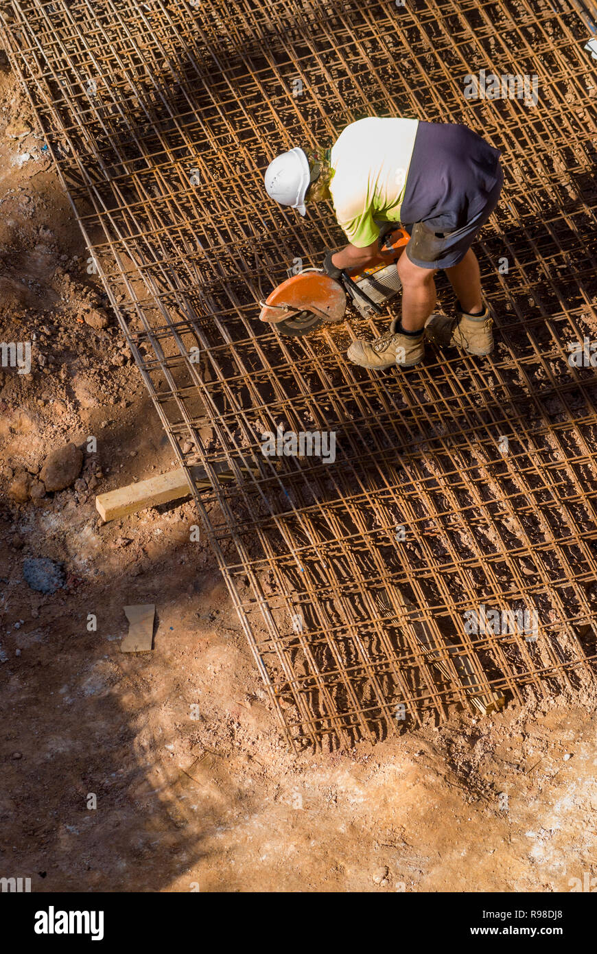 Workman cutting iron mesh, vertical Stock Photo