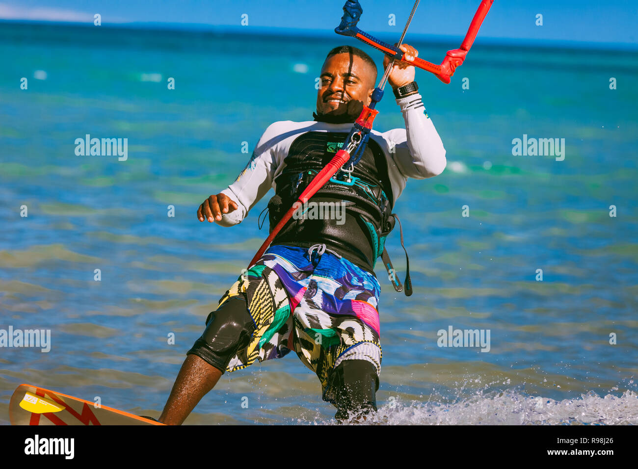 Egypt, Hurghada - 30 November, 2017: Close-up kitesurfer on the surfboard holding the kite straps. Red sea background. The sportsman having fun and en Stock Photo
