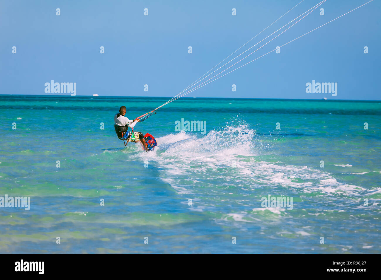 Egypt, Hurghada - 30 November, 2017: The kiteboarder gliding over the Red sea surface. The professional surfer on the board holding the kite straps. T Stock Photo