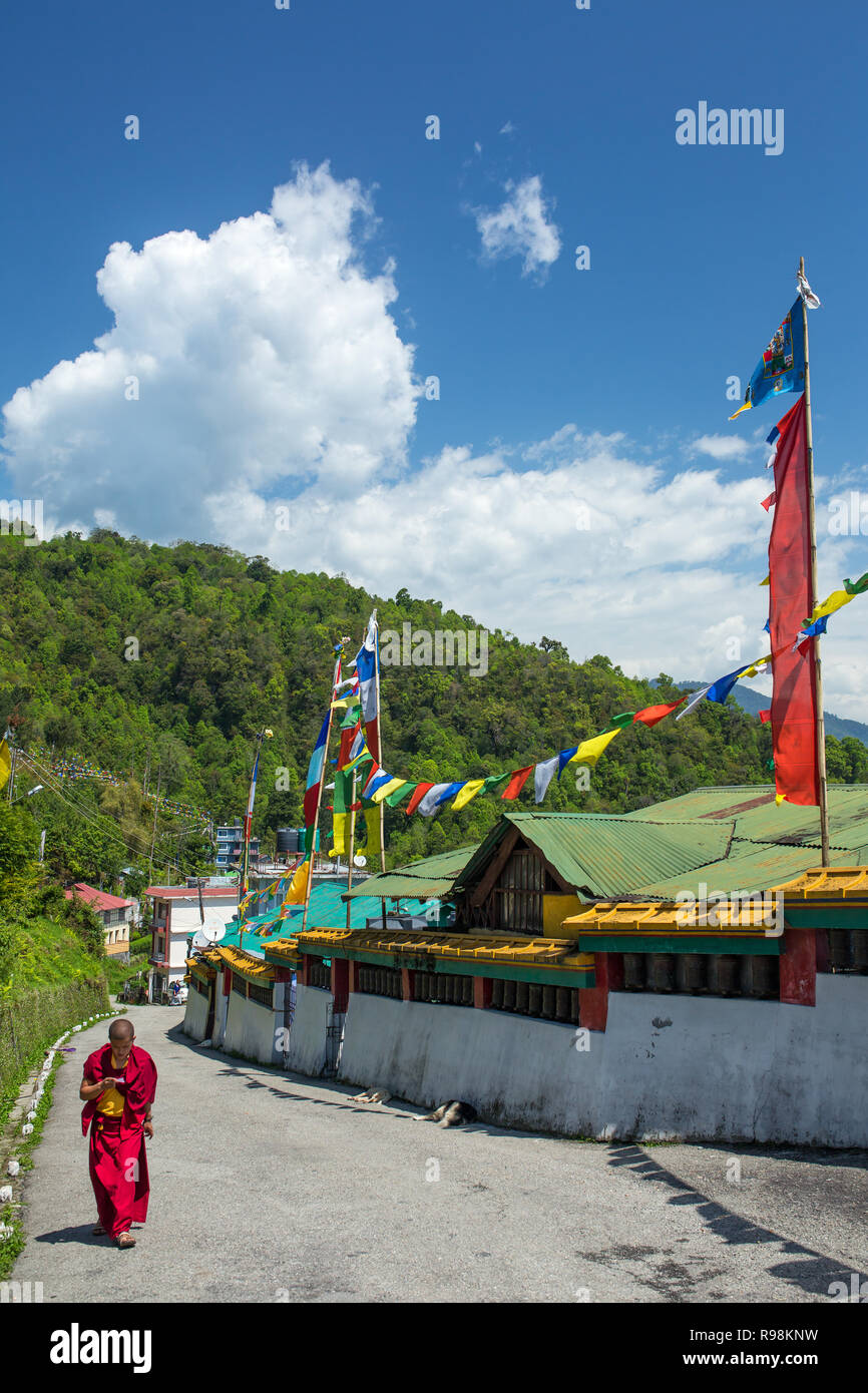 Sikkim, India - May 2, 2017: Tibetan buddhist novice walk along the prayer wall in Rumtek Monastery in Gangtok, Sikkim, India Stock Photo