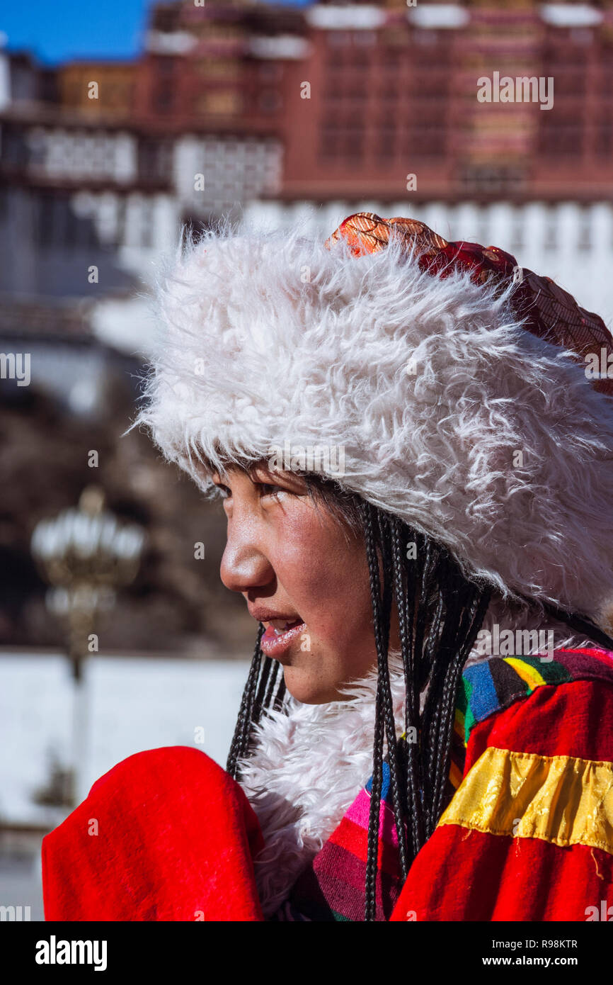 Lhasa, Tibet Autonomous Region, China : Portrait of Young Tibetan woman in traditional costume next to Potala palace. First built in 1645 by the 5th D Stock Photo