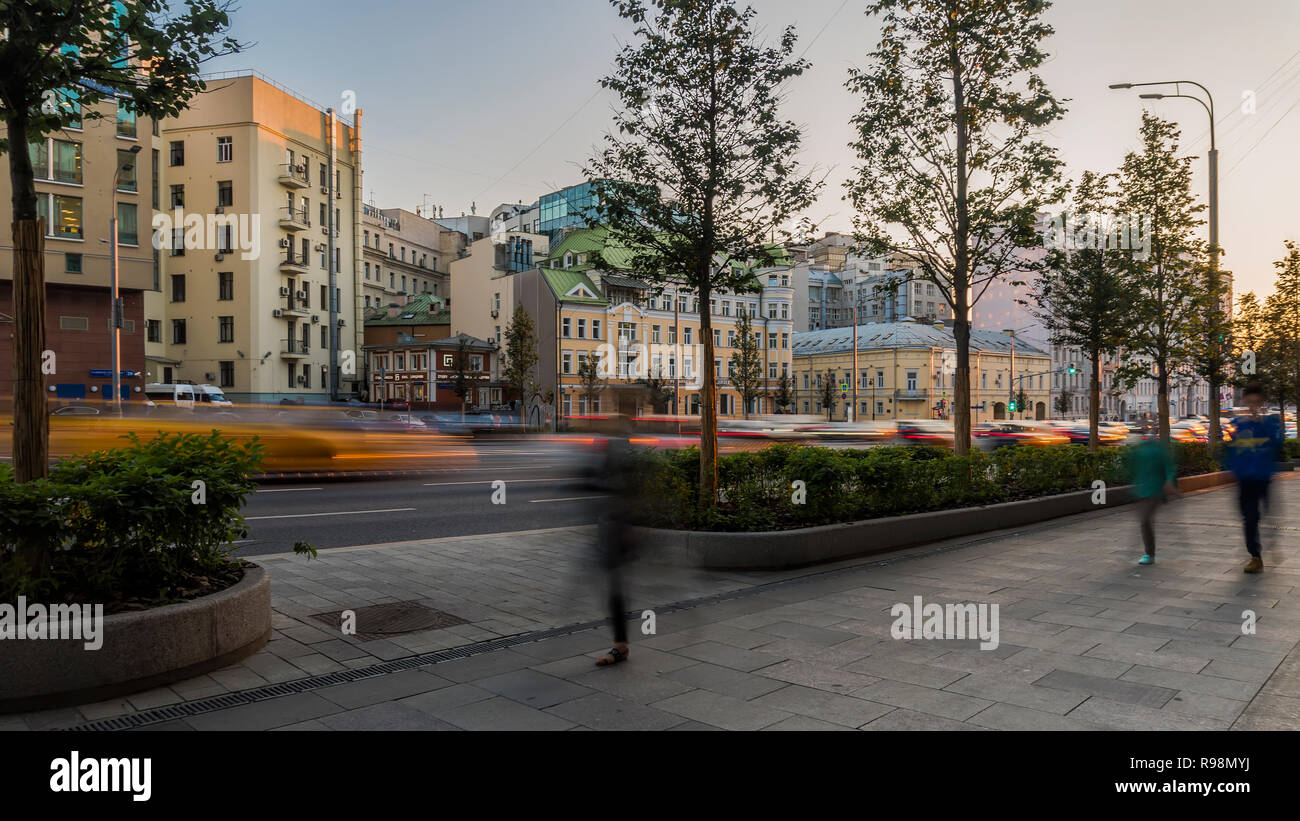 the flow of pedestrians and cars following the city street Stock Photo ...