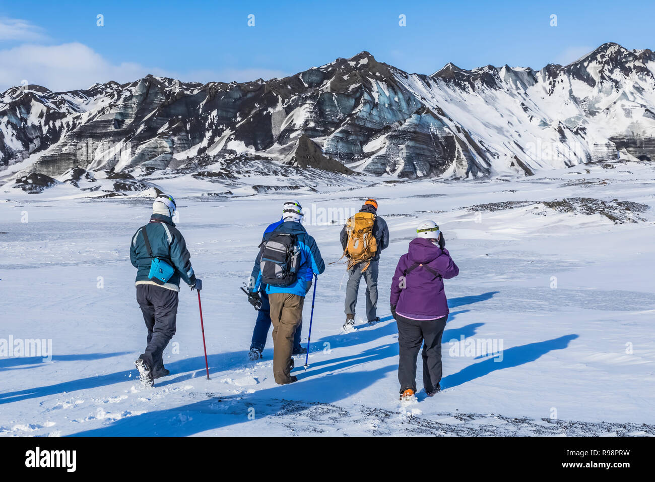 Adventurers walking on an ice cave tour to a lobe of Mýrdalsjökull Glacier, which sits atop Katla Volcano, in winter in Iceland [No model releases; av Stock Photo