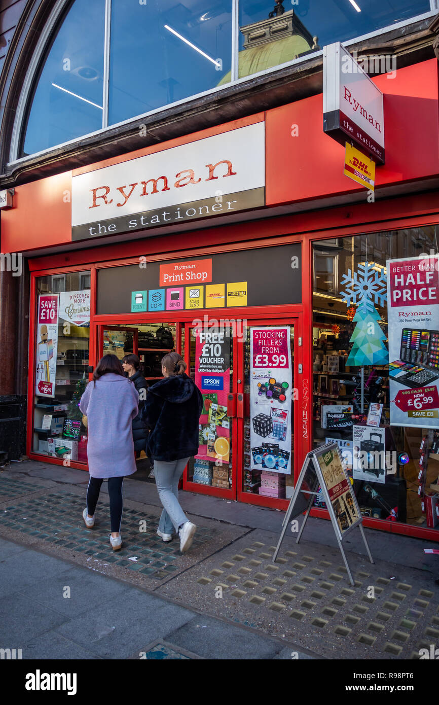 couple walking towards the exterior of the Ryman Stationery Shop on Tottenham Court Rd, Bloomsbury, London W1, England Stock Photo