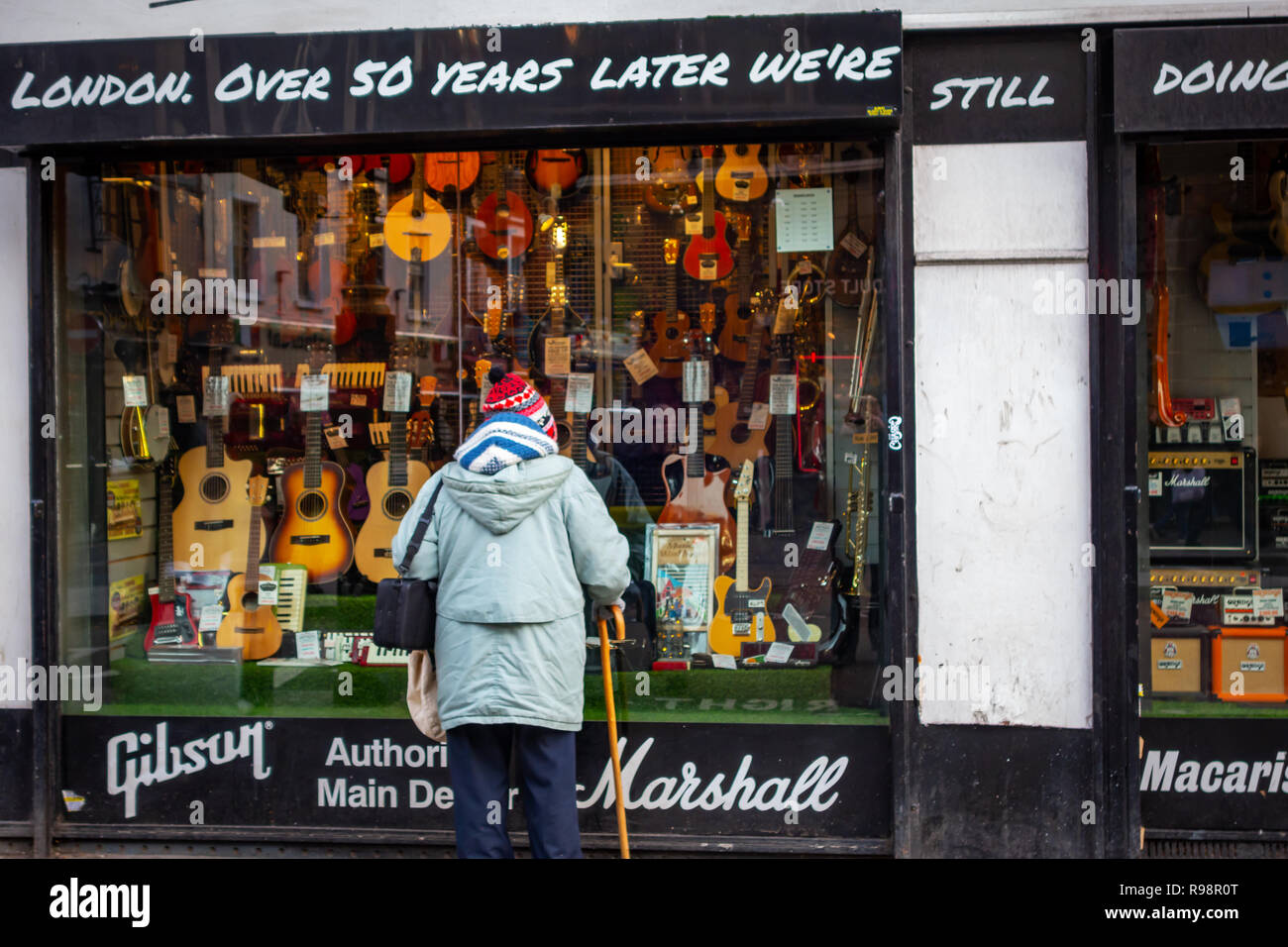 Older lady looking into the store shop front of Famous Macaris Musical