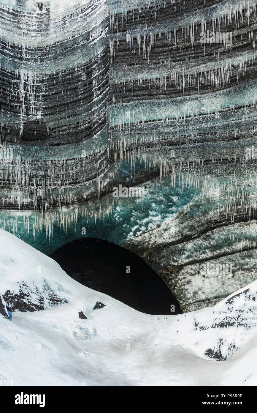 Icicles at entrance to an ice cave in a lobe of Mýrdalsjökull Glacier, which sits atop Katla Volcano, in winter in Iceland Stock Photo