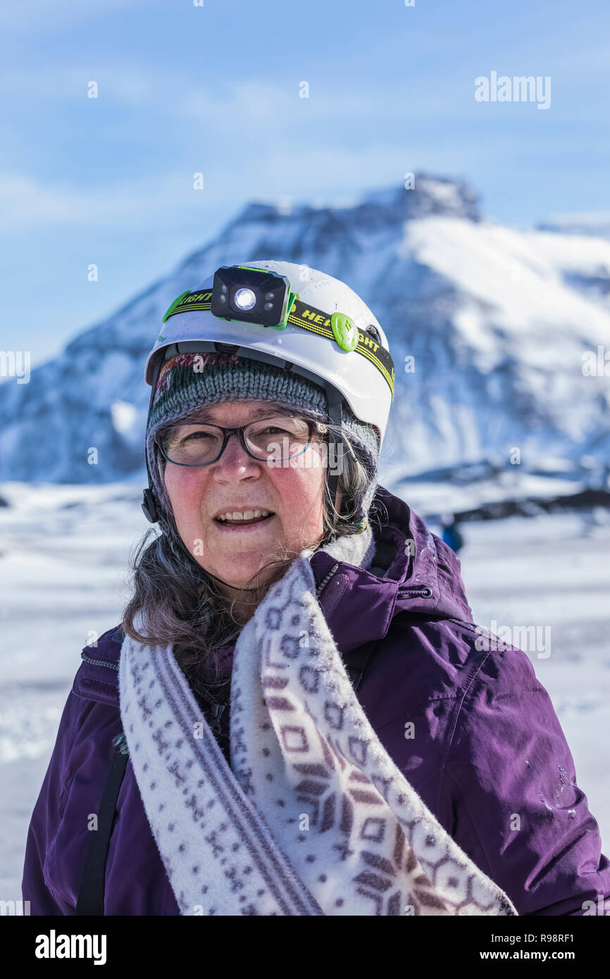 Karen Rentz on an ice cave tour at Mýrdalsjökull Glacier, with Hafursey in the distance, a location for the Star Wars film Rogue One, in winter in Ice Stock Photo