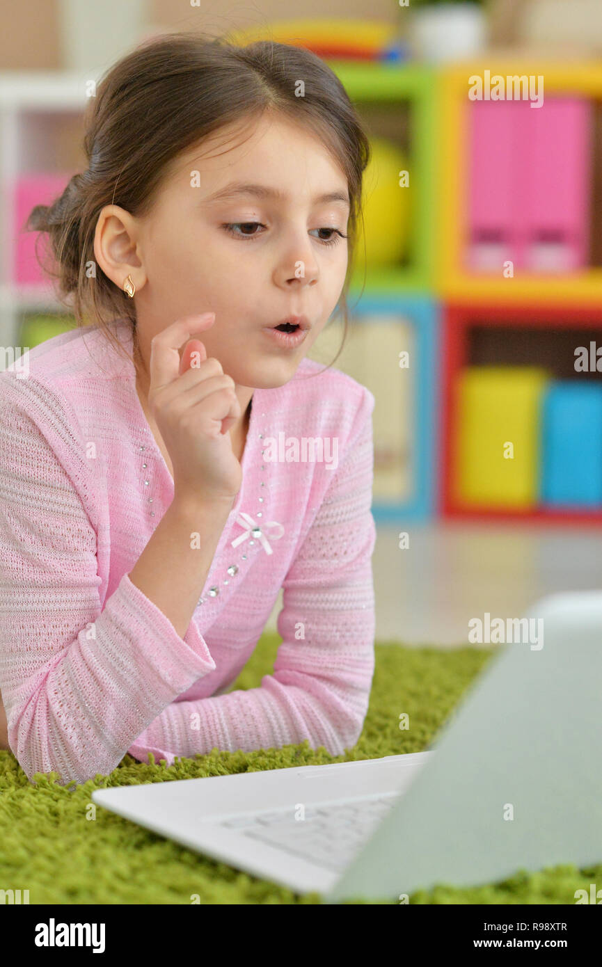 Cute girl using modern laptop while lying on floor Stock Photo - Alamy