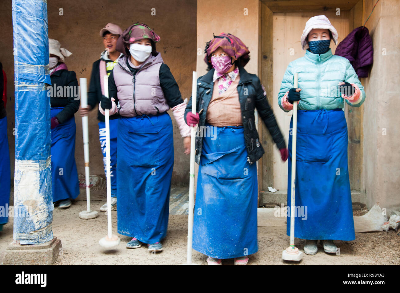 Parishioners form a line to tamp down the newlylaid floor of a temple