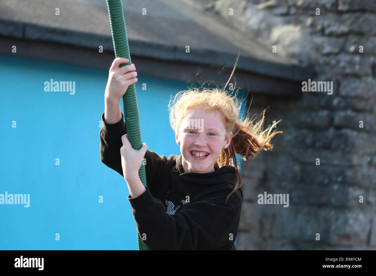 child smiling on the swings on Sunshine Park, Skegness Stock Photo