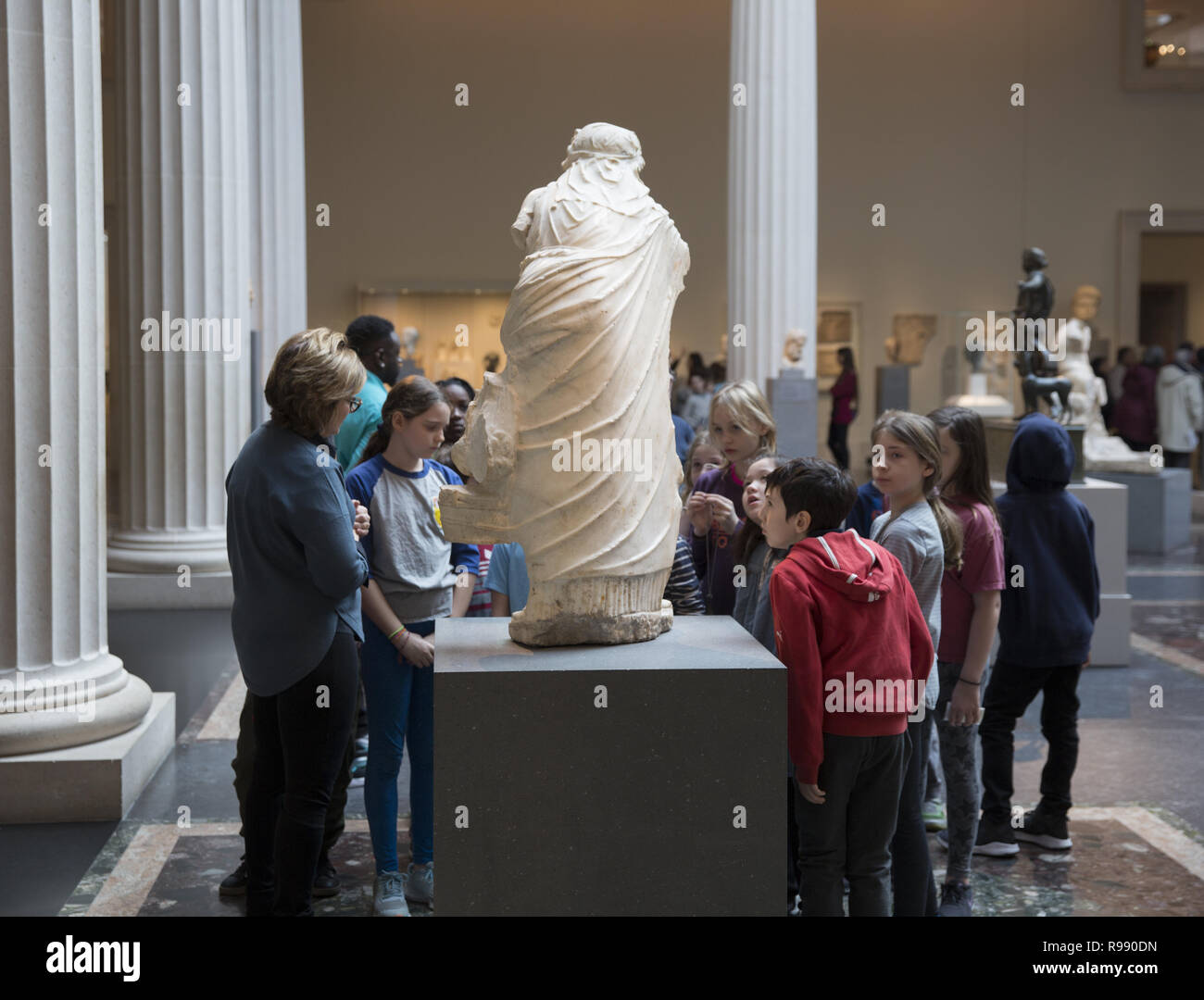 Class of public school students discuss a statue in the Greek & Roman gallery at the  Metropolitan Museum Of Art, NY City. Stock Photo
