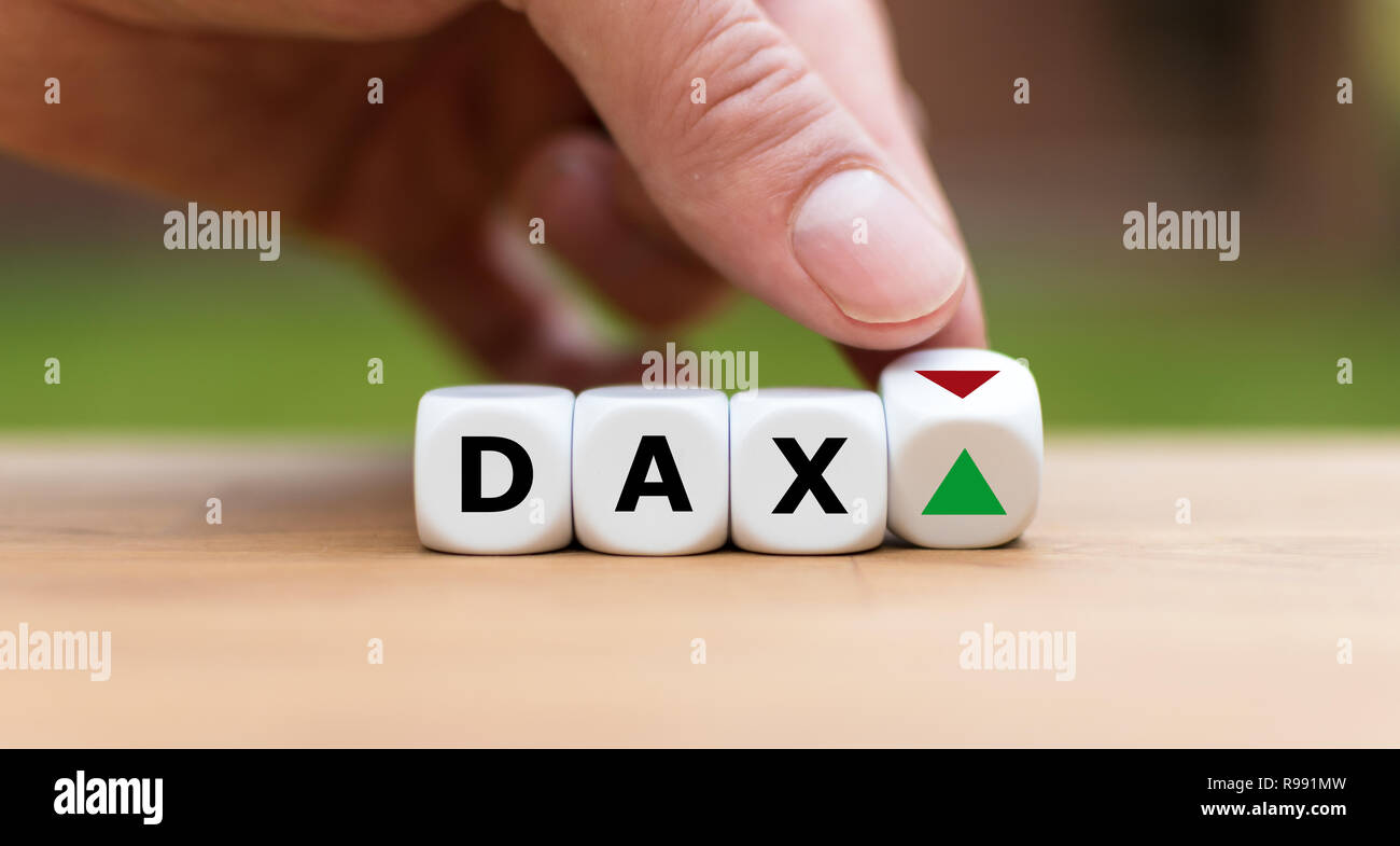 Hand is turning a dice and changes the direction of an arrow symbolizing that the German Stock Index DAX is changing the trend and goes up instead of Stock Photo