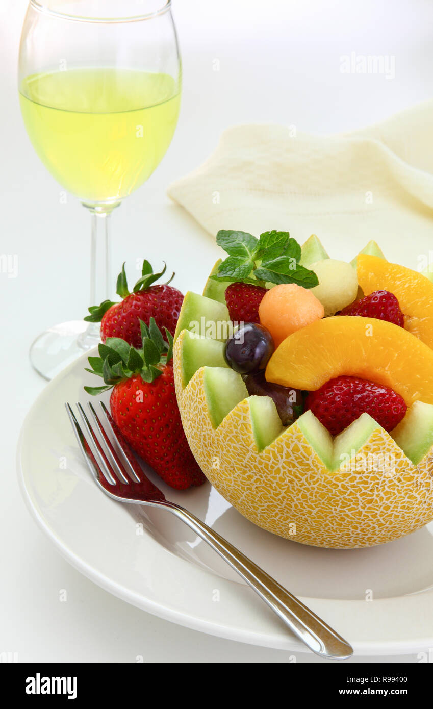 Fancy cut melon with assorted fruit inside and juice to drink Stock Photo
