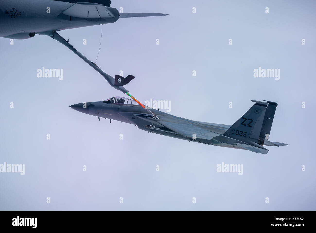 A KC-135 Stratotanker boom extends and refuels an F-15C Eagle over the East China Sea Dec. 11, 2018.  The 909th Air Refueling Squadron helps ensure a free and open Indo-Pacific by providing air refueling to U.S., allies and partners within the area of responsibility.  (U.S. Air Force photo by Airman 1st Class Matthew Seefeldt) Stock Photo