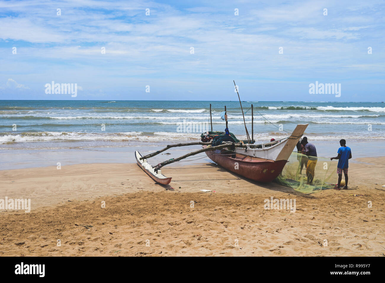 Fishermen and traditional fishing boats in Weligama, Sri Lanka Stock Photo