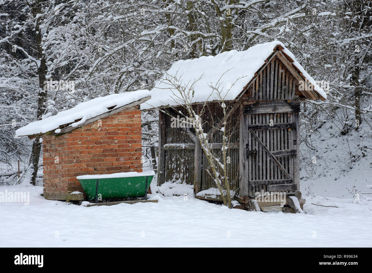 traditional outbuildings at a house in a rural hungarian village covered in snow from a fresh snowstorm zala county hungary Stock Photo