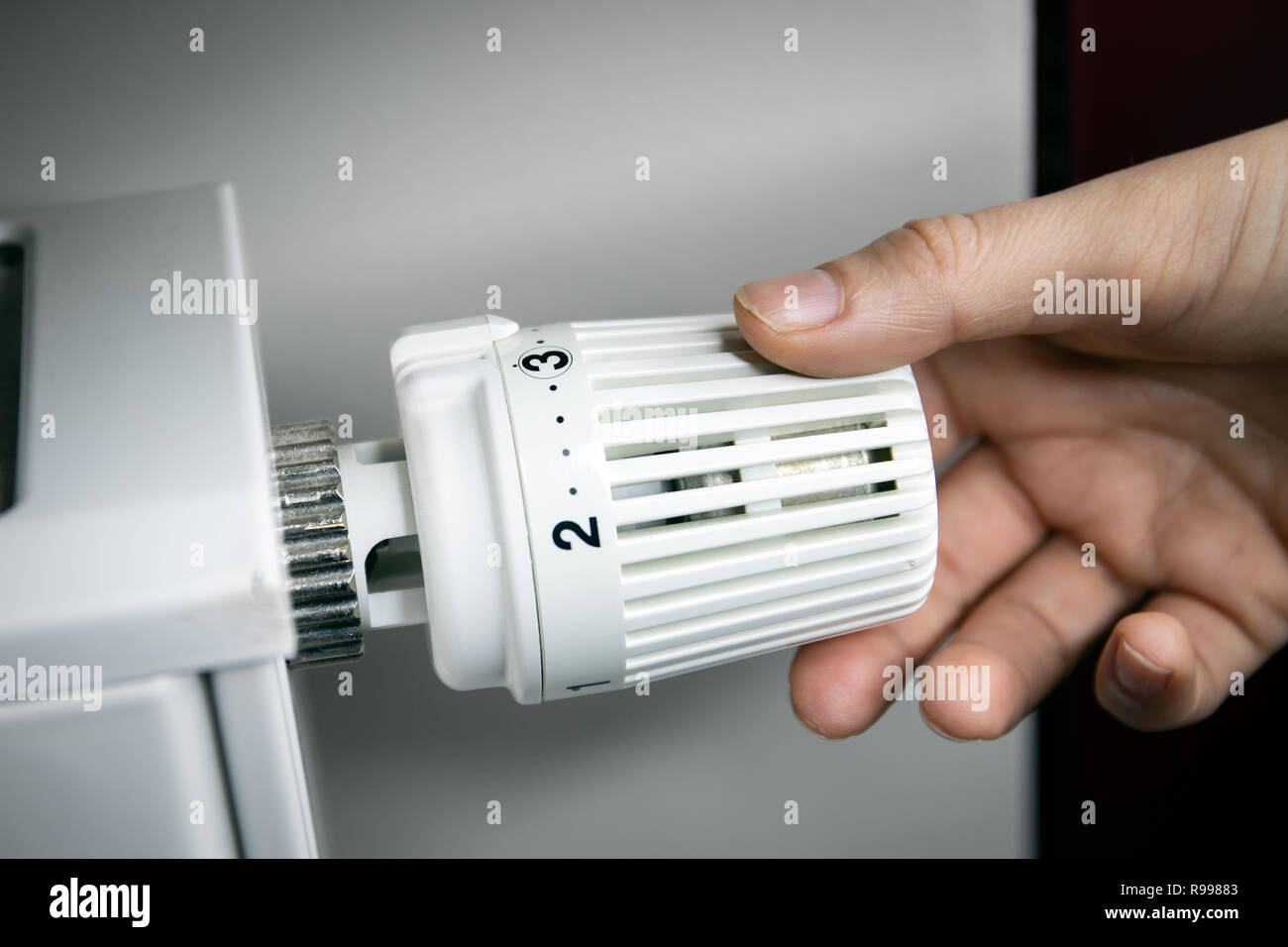 hand adjusting temperature on radiator. energy saving concept Stock ...