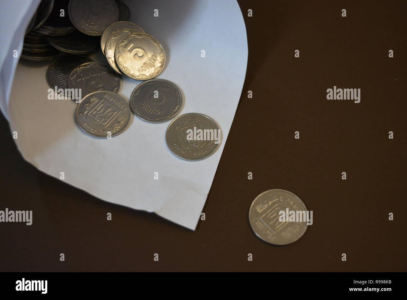 An envelope with money, in a white paper bag are small money, white light metal pennies, cash savings in the banking system, a bank and bank payments. Stock Photo