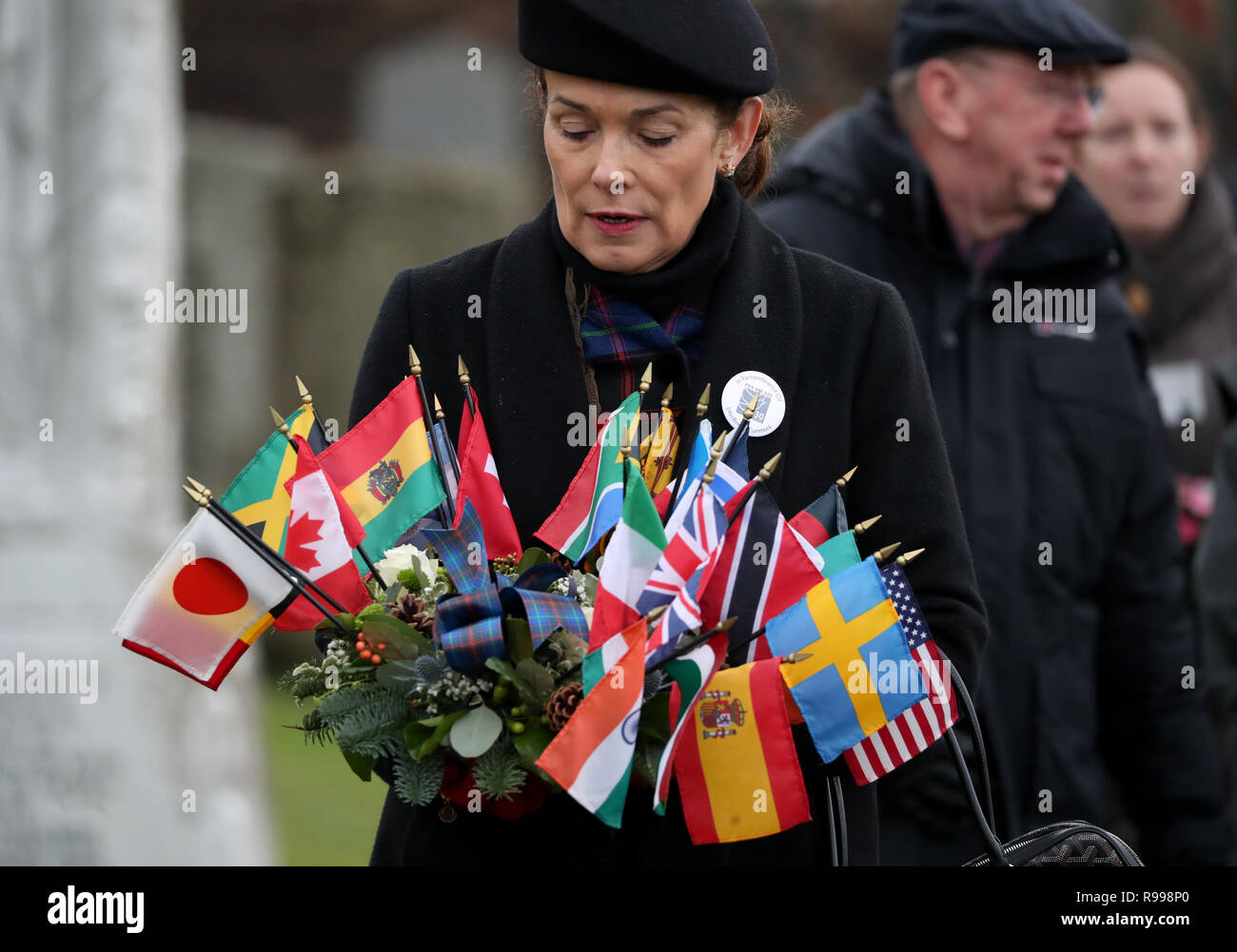 Carisa Harris-Adamson, from San Francisco, lays a wreath in memory of her uncle John Cummock who was on the flight during the commemoration service in the Memorial Garden at Dryfesdale Cemetery in Lockerbie to mark the 30th anniversary of the Lockerbie bombing. Stock Photo