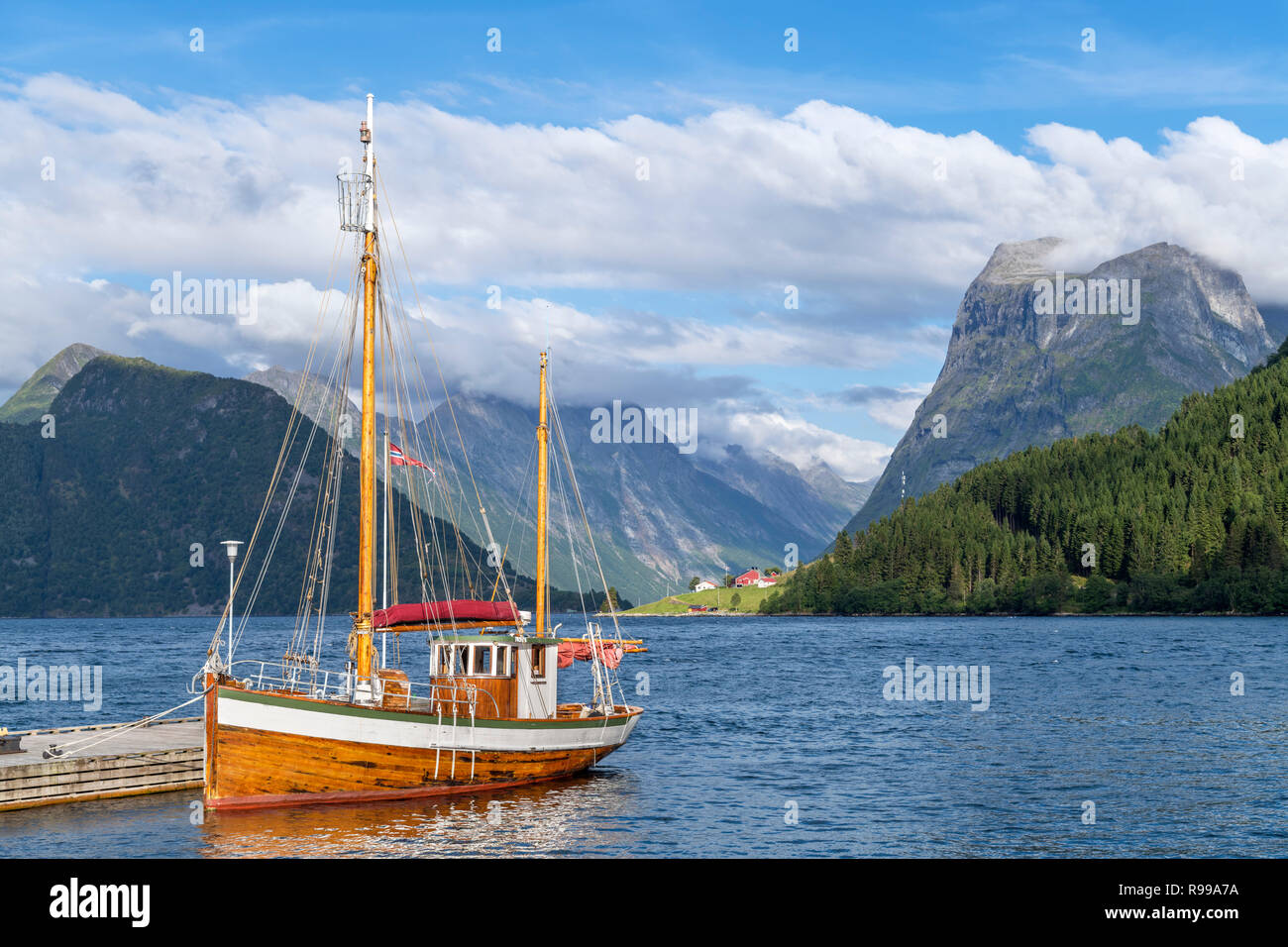 Norwegian fjords. Traditional boat moored at a jetty outside the Sagafjord Hotel in the late afternoon, Sæbø, Hjørundfjorden, Møre og Romsdal, Norway Stock Photo