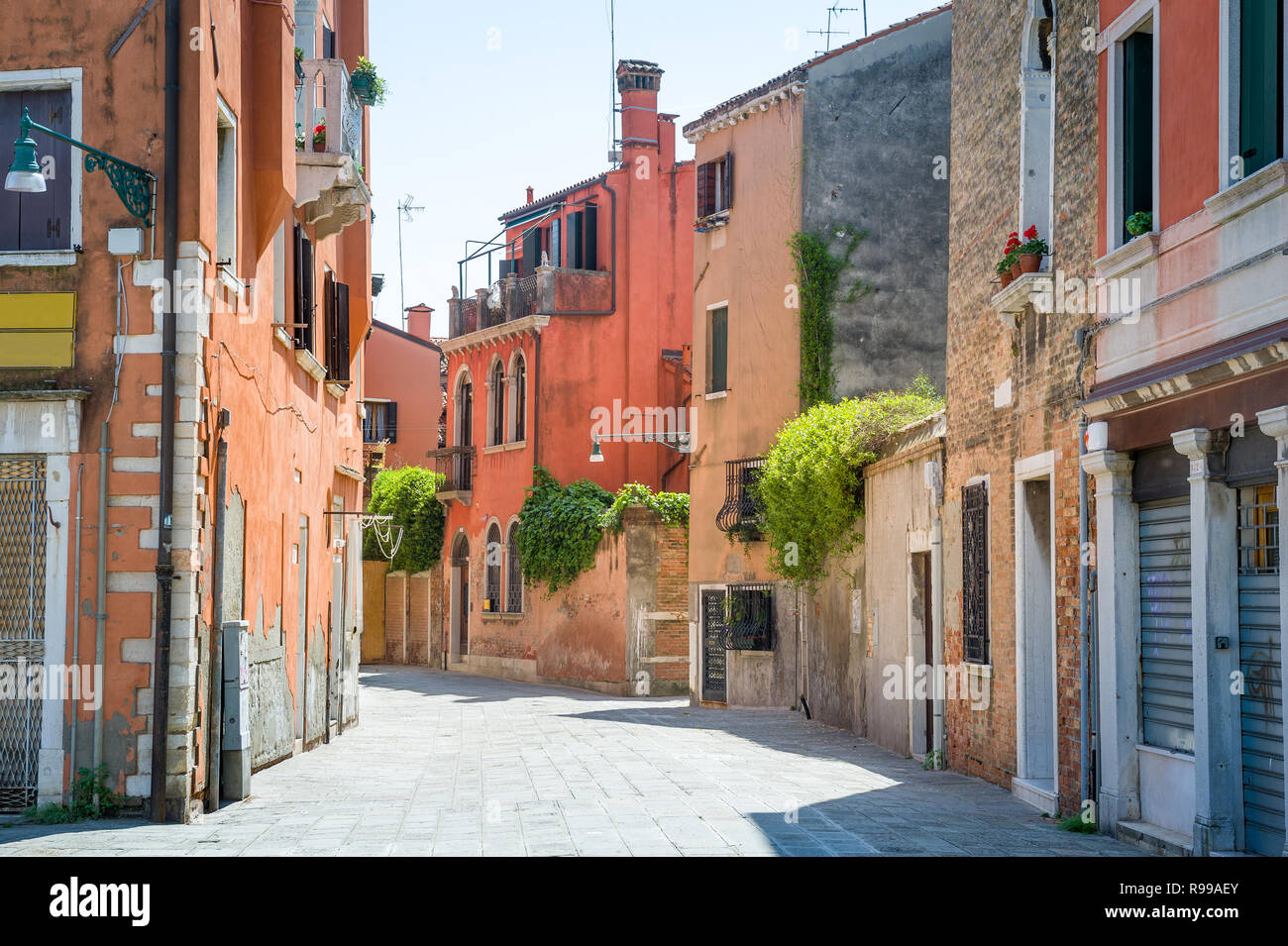 Colorful old narrow street in the center of Venice with traditional italian houses. Italy. Stock Photo