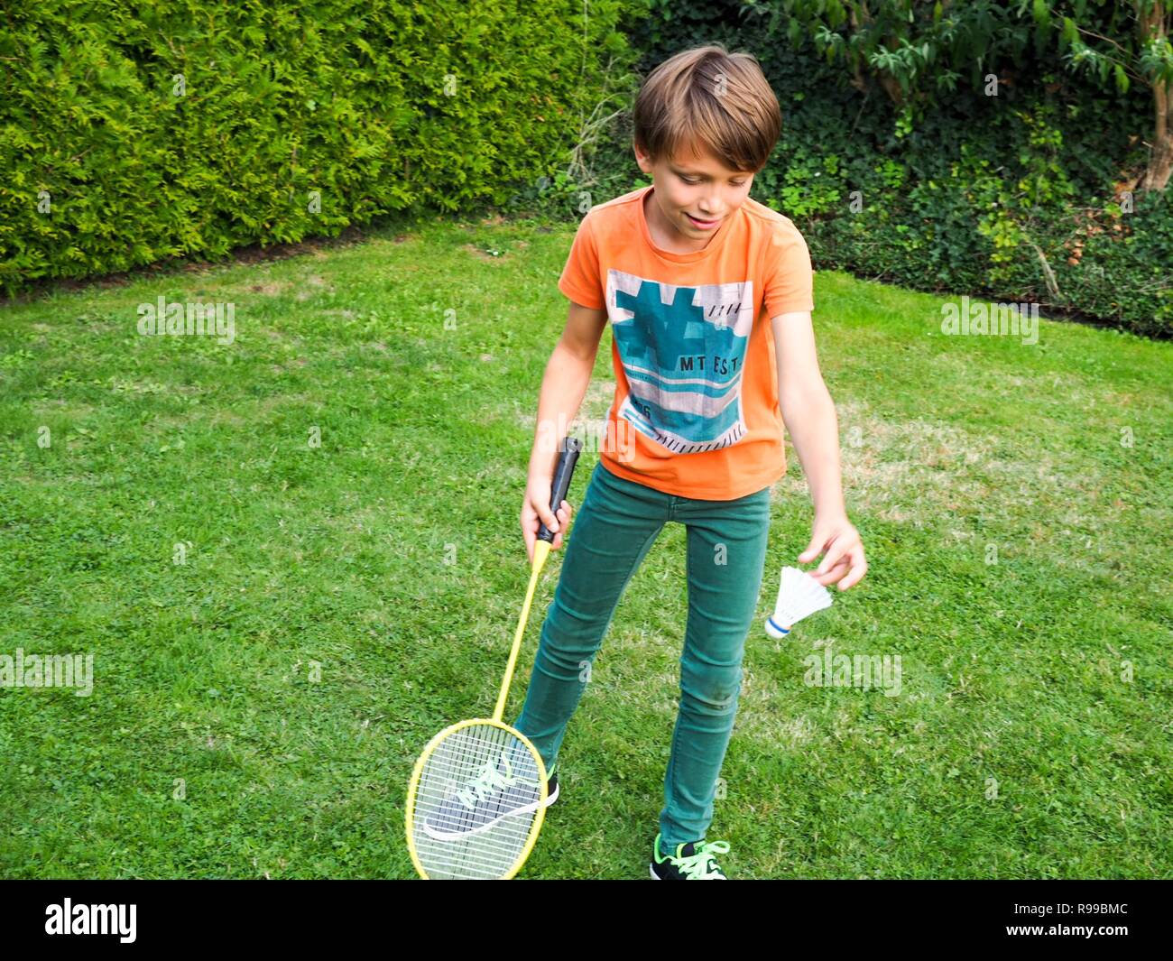 Young boy playing badminton, about to serve the shuttle Stock Photo