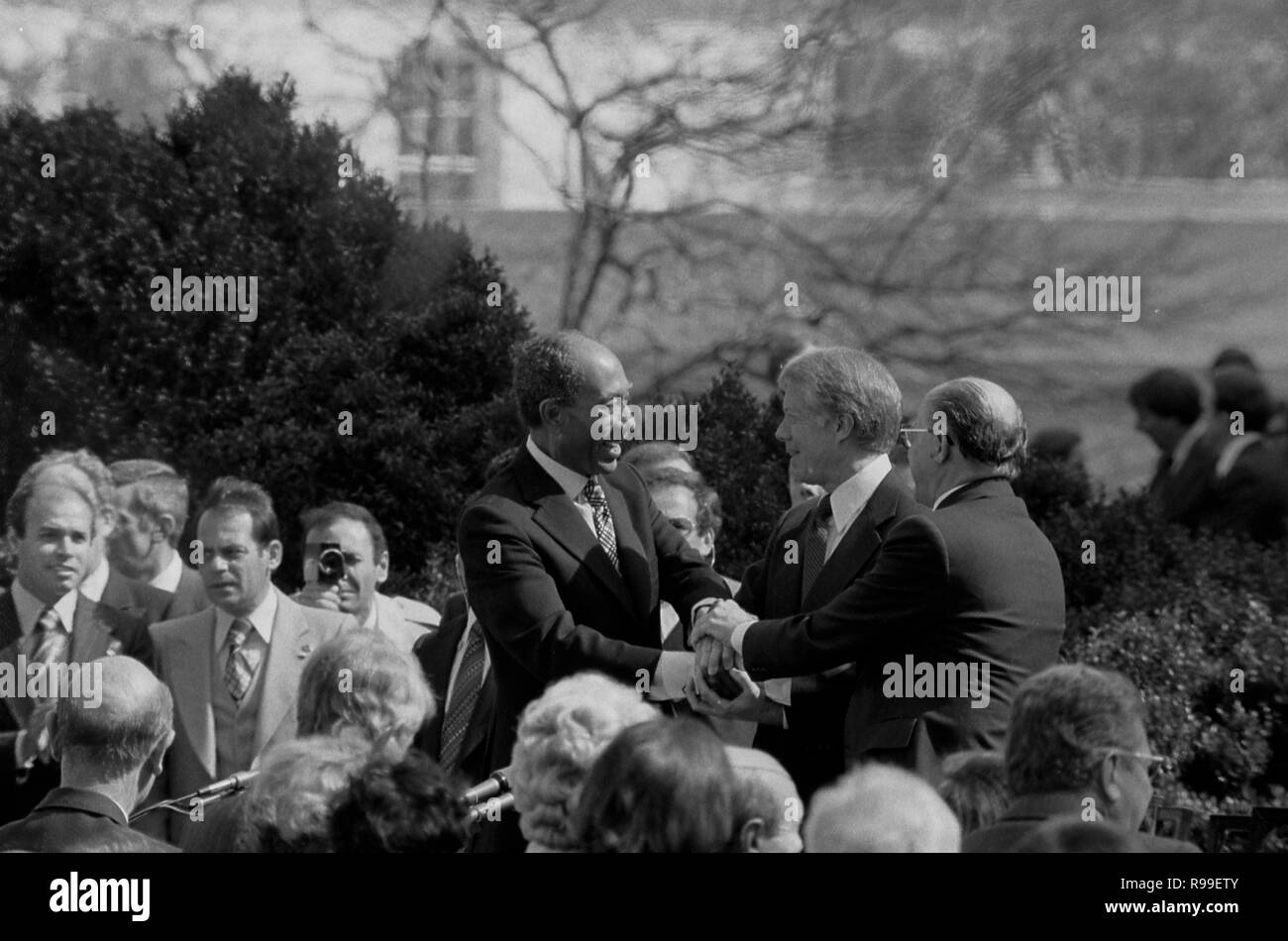 President Jimmy Carter shaking hands with Egyptian President Anwar Sadat and Israeli Prime Minister Menachem Begin at the signing of the Egyptian-Israeli Peace Treaty on the grounds of the White House. 1979 Mar. 26 Stock Photo