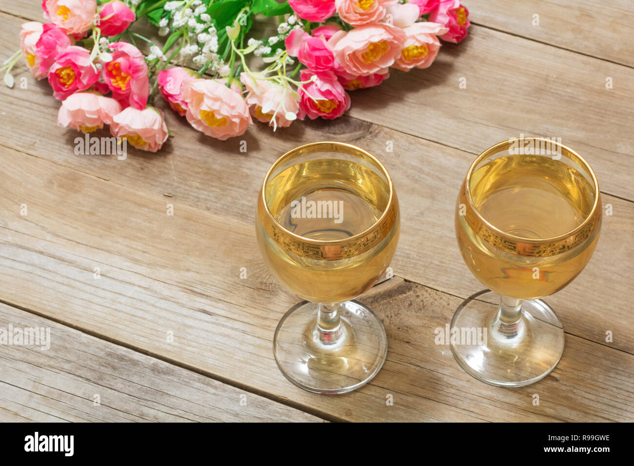 Two glasses of white wine and flowers Stock Photo