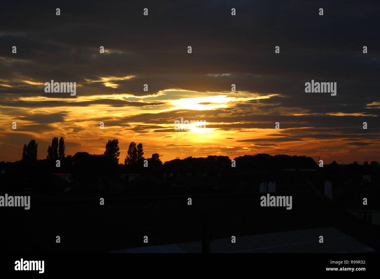 sunset with clouds over skegness rooftops Stock Photo