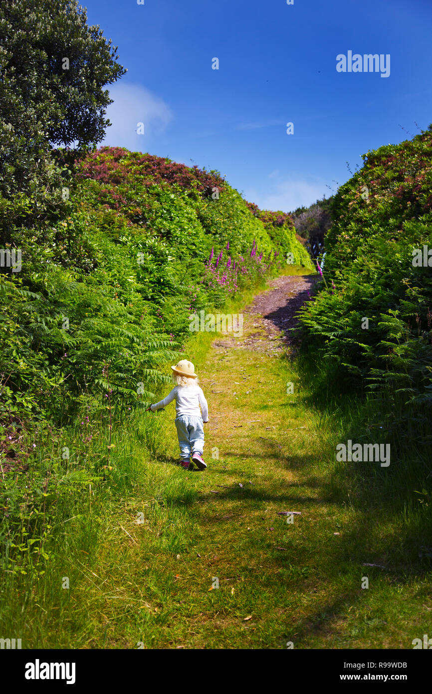 A little girl walking away up a path Stock Photo