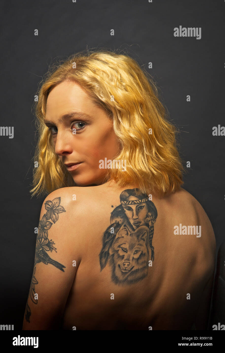 A young blond girl with a tattooed back Stock Photo