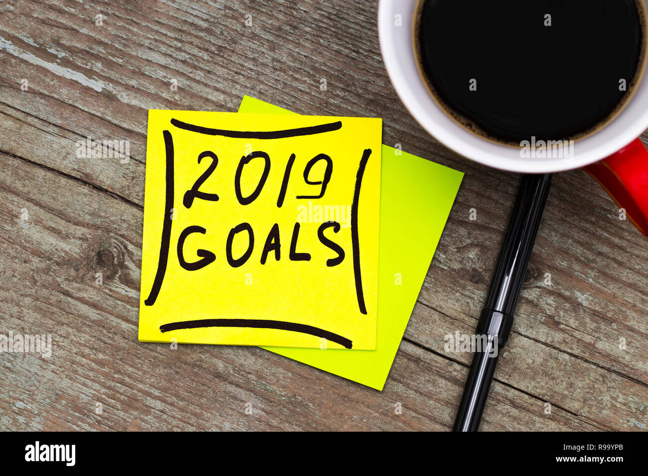 2019 goals - handwriting in black ink on a sticky note with a cup of coffee, New Year resolutions concept. Stock Photo