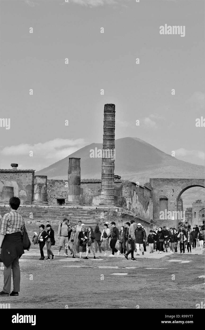 Pompeii, Italy - October 23rd 2018: Tourists explore the ruins of the ancient Roman city of Pompeii, with the Mount Vesuvius volcano in the background Stock Photo