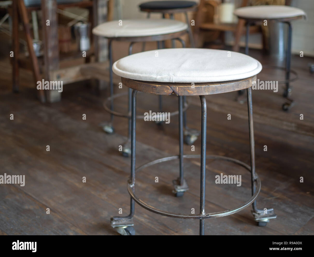 Old vintage iron and wooden bar stools with wheels with black and white