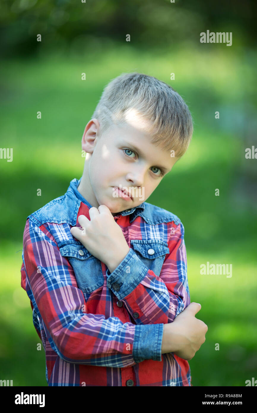 boy with a displeased facial expression in the garden Stock Photo