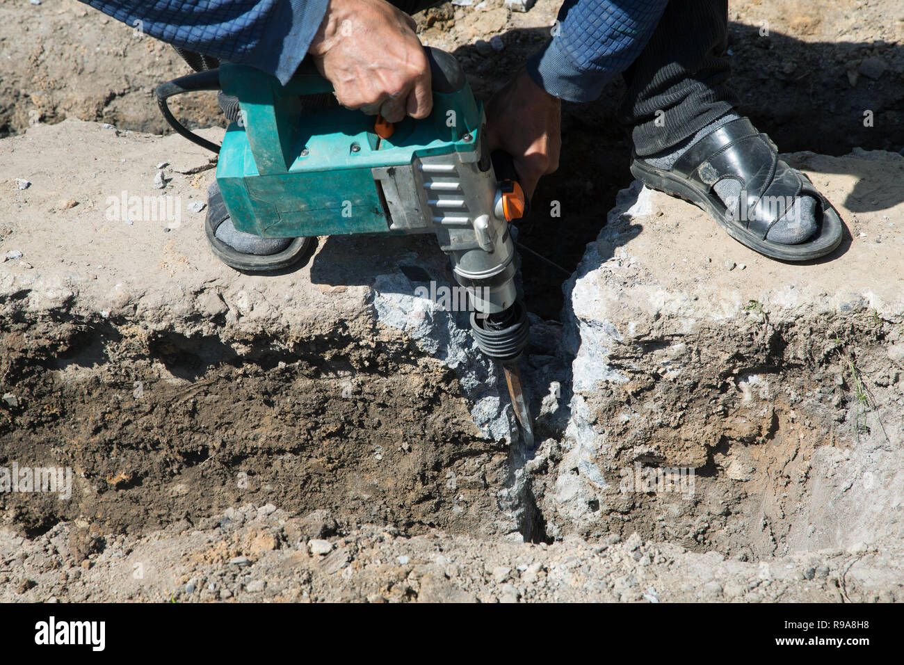 Worker hammer smashes the concrete foundation Stock Photo